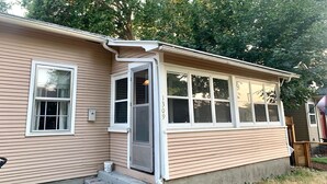 Een gelijkvloers huis met een veranda, een deur en een raam met het nummer 1309 op de gevel.