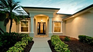 A house with a front entrance, a covered porch, and a pathway leading to the door. - Luxury 4 BR/3BA Waterview Home w/ Pool + Spa with work space (Bradenton)