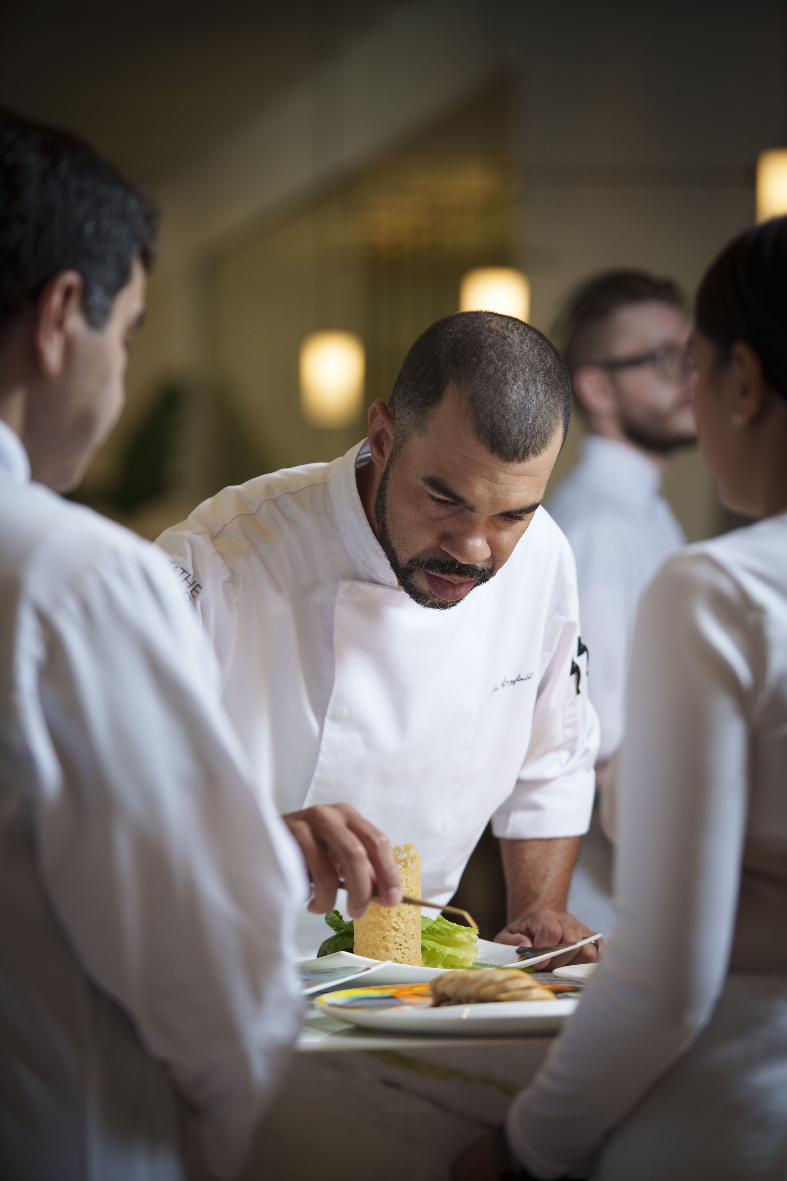 Un chef préparant et servant des plats aux clients dans un restaurant.