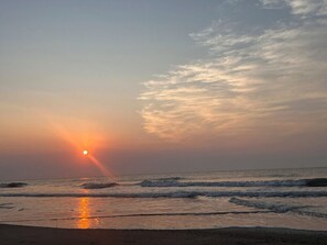A beach with waves and a sunset. - Elevator, Pets Welcome >5 min walk to Beach & Dining! (Tybee Island)