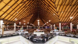 Un restaurante amplio con techo de madera y luz moderna.
