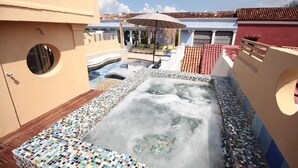 A rooftop pool area with a hot tub, tiled deck, and a covered seating area. - Splendid Colonial Villa with Rooftop & Jacuzzi (Cartagena)