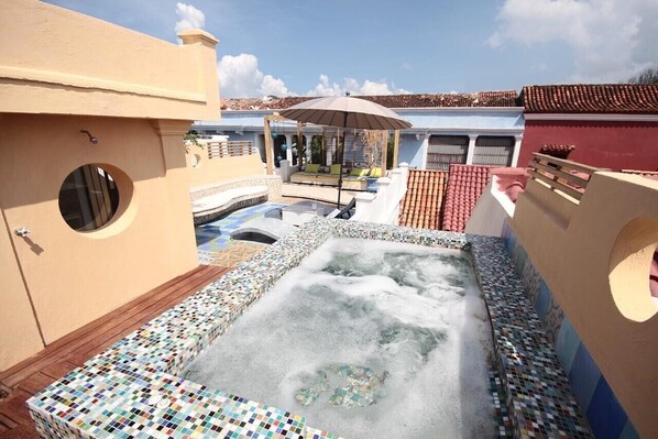 A rooftop pool area with a hot tub, tiled deck, and a covered seating area. - Splendid Colonial Villa with Rooftop & Jacuzzi (Cartagena)