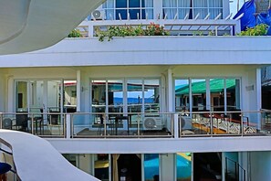 A multi-story building with balconies, large windows, and a pool area.