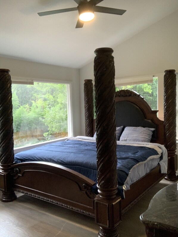 Un lit à baldaquin avec une structure en bois foncé et une couvre-lit bleue.