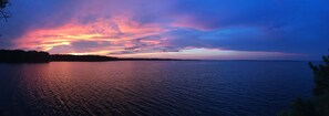 A calm body of water reflecting a sunset sky with a distant shoreline. - Eagles Point! Incredible Private Waterfront 3.5 acres. Long range water views! (Zavalla)