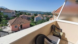 A balcony with a view of a town, a chair, and a table. - ♥Apartmani Kankaras | Sea View - Quiet Quarter♥ (Tivat)