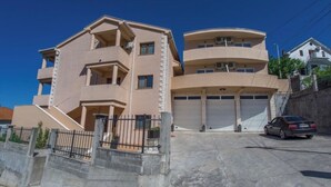 A multi-story residential building with a garage and a car parked in front. - ♥Apartmani Kankaras | Sea View - Quiet Quarter♥ (Tivat)