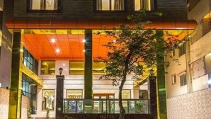 A modern hotel with a prominent entrance, multiple floors, and a well-lit facade. - Hotel Presidency in Electronic City (Anekal)