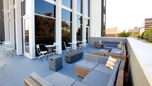 An outdoor seating area with modern furniture and large windows.