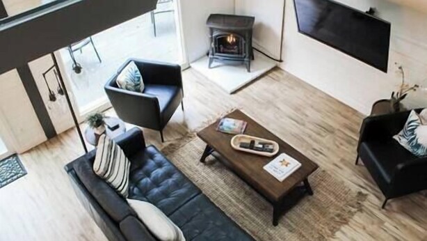 Een moderne woonkamer met een bank, een salontafel, een open haard en een flatscreen televisie.