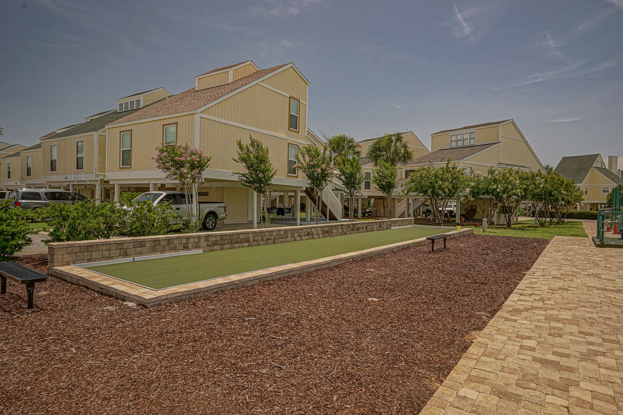 Un barrio residencial con casas, césped verde y un sendero para caminar.