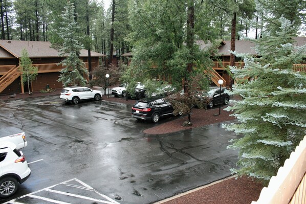 A parking lot with several cars, surrounded by trees and a lodge with a wooden exterior. - Pinetop Lakes Sports Village Beautiful 3 Bed 2 Bath Condo, Golf, Ski & much more (Pinetop)