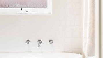 Bathtub, hair dryer, towels, shampoo