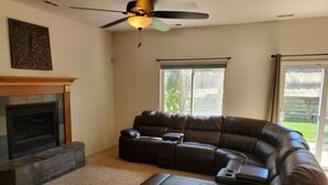 A living room with a sectional sofa, a fireplace, and a ceiling fan. - 2 Master Suites/3 King Beds/4 Bath/Mins to Airport (Colorado Springs)