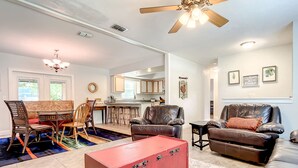 A spacious living room with a red trunk, leather sofas, and a dining area with a chandelier. - 💎Red Rooster cottage🌅💎🏄🏽‍♂  ️ (Port Orange)
