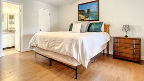 A bedroom with a bed, a nightstand, a dresser, a ceiling fan, and a painting on the wall. - 💎Red Rooster cottage🌅💎🏄🏽‍♂️ (Port Orange)