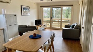 Une cuisine moderne équipée d’une table à manger, de chaises, d’un réfrigérateur et d’un ventilateur de plafond.