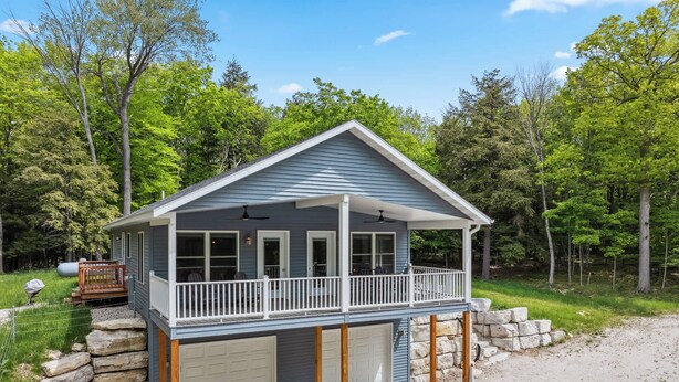 A single-story house with a covered porch, a garage, and a stone retaining wall. - Livin' the Dream in Fish Creek! (Fish Creek)