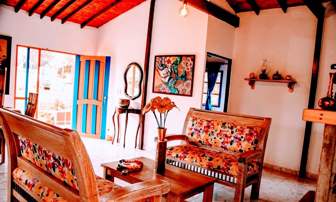 Um quarto aconchegante com móveis de madeira, um espelho e um quadro colorido na parede.