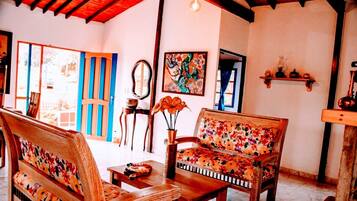 Um quarto aconchegante com móveis de madeira, um espelho e um quadro colorido na parede.