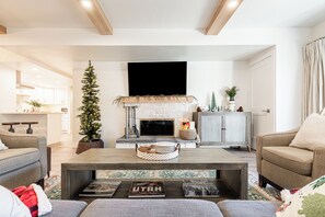 Un salon moderne avec une cheminée, un sapin de Noël et une table basse sur laquelle est posé un livre sur le thème de l’Utah.