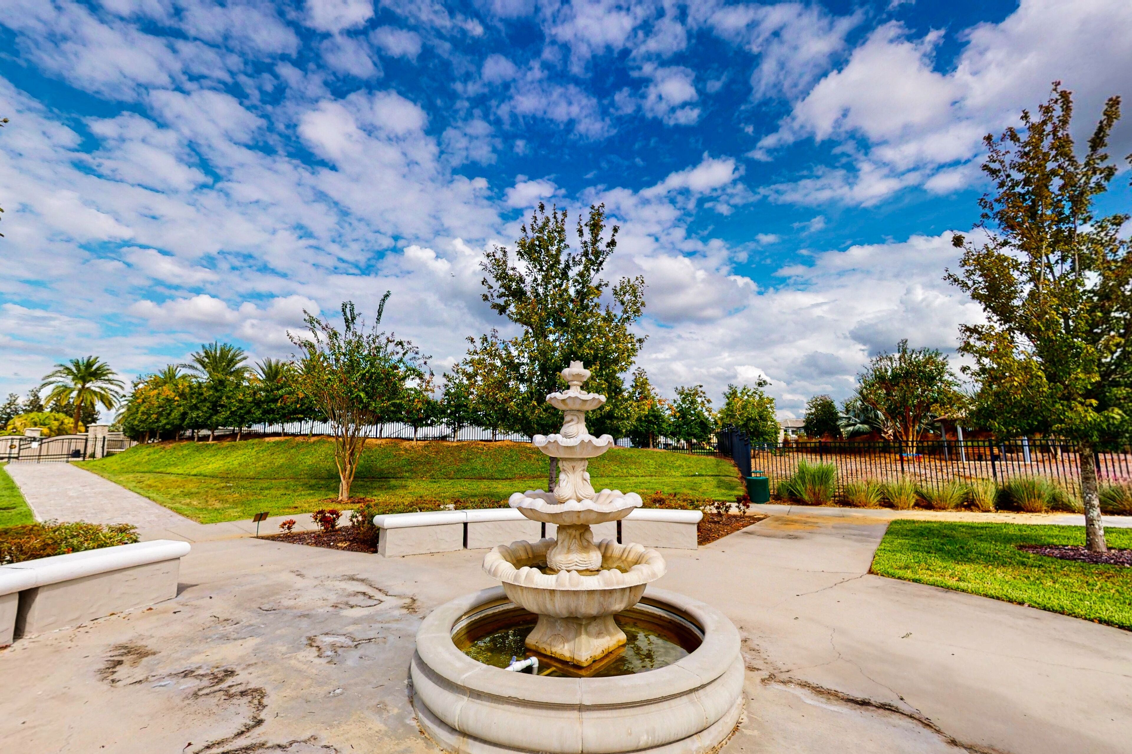 A fountain with multiple tiers in a park setting.