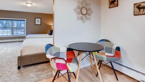 A bedroom with a bed, a window, a wall decoration, and a small table with chairs. - Private suite with kitchenette, gorgeous views, minutes from Frisco and Breck (Breckenridge)