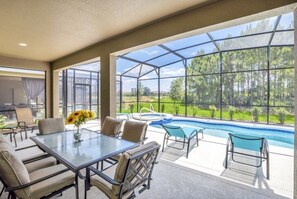A covered outdoor area with a pool, seating, and a view of a forest. - 6 Bed 4 Bath Solterra Beautiful Home! 6 Bedroom Villa by RedAwning (Davenport)