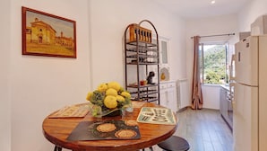 Une cuisine avec une table en bois, un meuble à bouteilles et une fenêtre donnant sur un beau paysage.