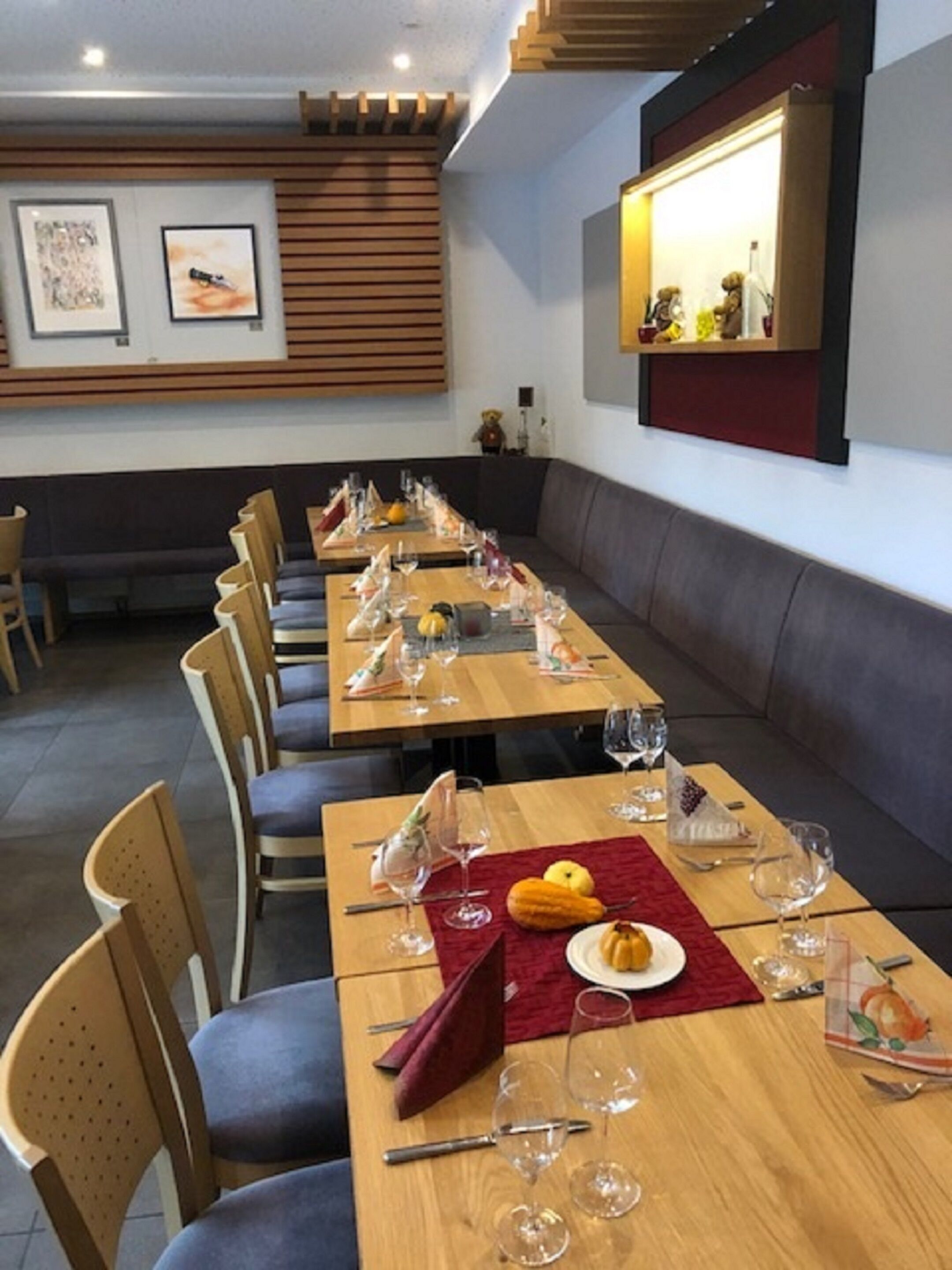 A dining area with long tables, chairs, and a wooden ceiling.
