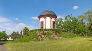 A small, standalone building with a dome roof, situated on a grassy hill with trees around. - WeinMotel Simon 1 a (Alzenau)