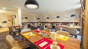 A hotel dining area with multiple tables, chairs, and pendant lighting. - Altstadthotel Kneitinger (Abensberg)
