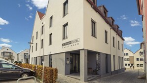 A modern hotel with a sign reading "ALTSTADT HOTEL KNEITINGER". - Altstadthotel Kneitinger (Abensberg)