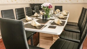 A conference room with a long table set for a meeting, surrounded by black leather chairs. - Sanderling (Scarborough)