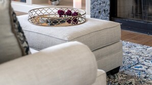 A living room with a fireplace, a sofa, a coffee table with decorative items, and a bookshelf. - Walk to TPC | Pinnacle Peak Views | Gated Retreat (Scottsdale)