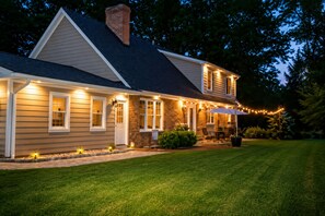 A two-story house with a covered patio and string lights. - Solon Serenity: A Beautiful, Serene Setting with Mtn Views, Weekly and Monthly Discounts! (Mount Solon)