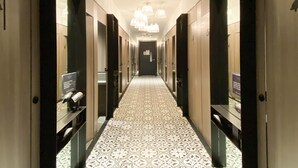 A hotel corridor with patterned flooring, mirrored walls, and modern lighting fixtures. - ST Signature Jalan Besar, SHORT OVERNIGHT, 13 hours: 6PM-7AM (Singapore)