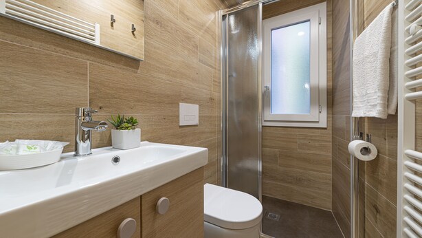 Une salle de bain moderne équipée d’une douche, de toilettes et d’un lavabo.