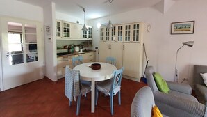 A compact living space with a dining area, kitchen, and a sofa. - Terraced house a stone's throw from the sea (Capalbio Scalo)