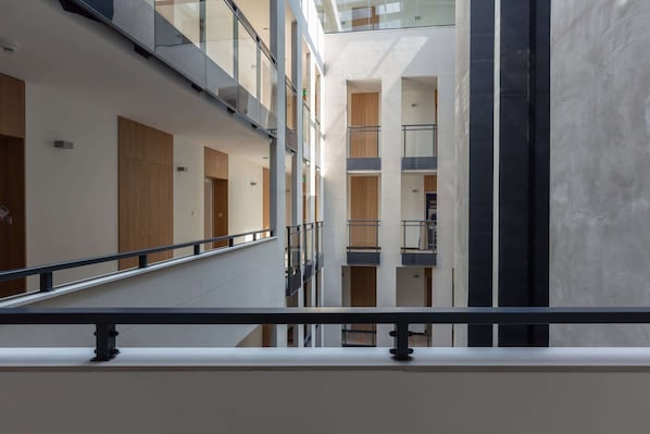 A multi-level interior with a central atrium, glass railings, and a modern design.
