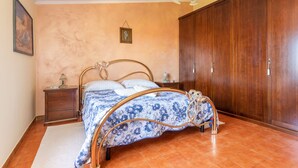 Un dormitorio con cama, armario de madera y mesita de noche.