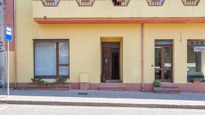 Un edificio amarillo con puerta de madera, una ventana y un letrero que dice "MOBINDI".