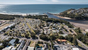 Vista aérea de un pueblo costero con un puerto deportivo, zonas residenciales y una playa.