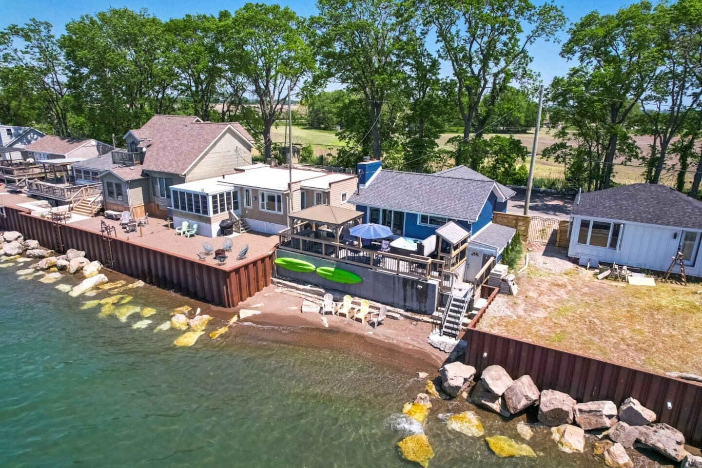 A waterfront property with multiple houses, a dock, and a small boat.