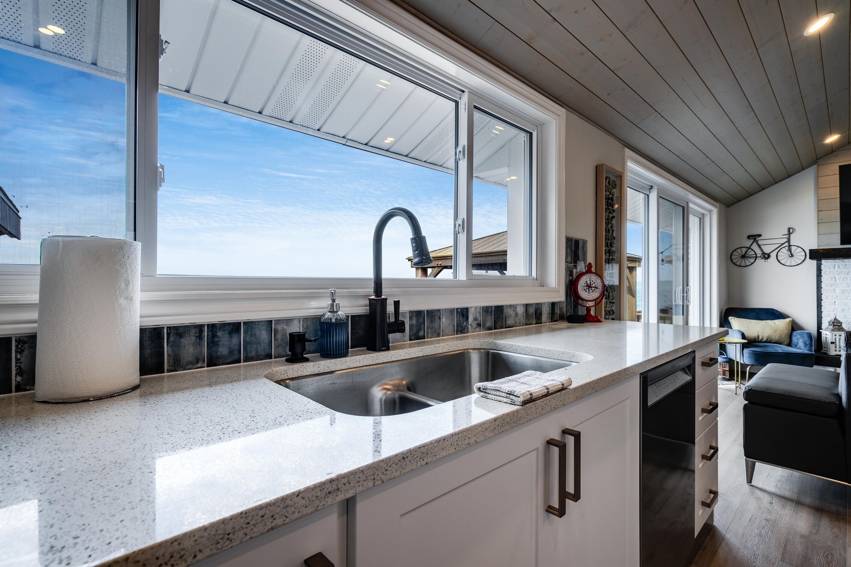 A kitchen with a large window, a sink, and a countertop.