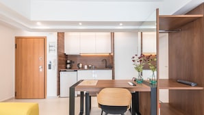 Una cocina moderna con armarios blancos, encimera de madera y un comedor con mesa y sillas.
