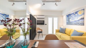 Una sala de estar moderna con dos sofás amarillos, una mesa de centro de madera y un cuadro en la pared.