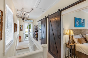 Staircase leads to a cozy bedroom with a comfortable bed and reading nook.