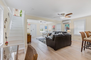 Relax in this spacious living area with a high ceiling, featuring a sofa, armchair, and dining table.